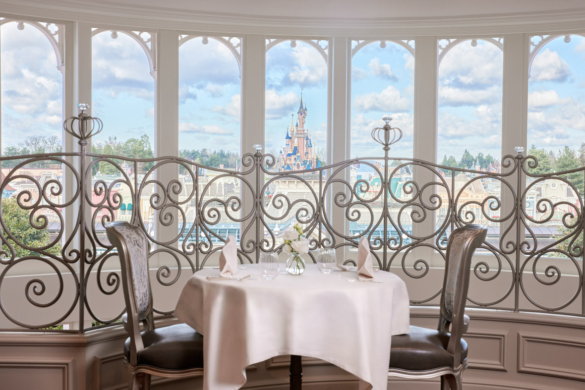The Deluxe Lounge shows a table with two chairs that overlooks Disneyland Park.